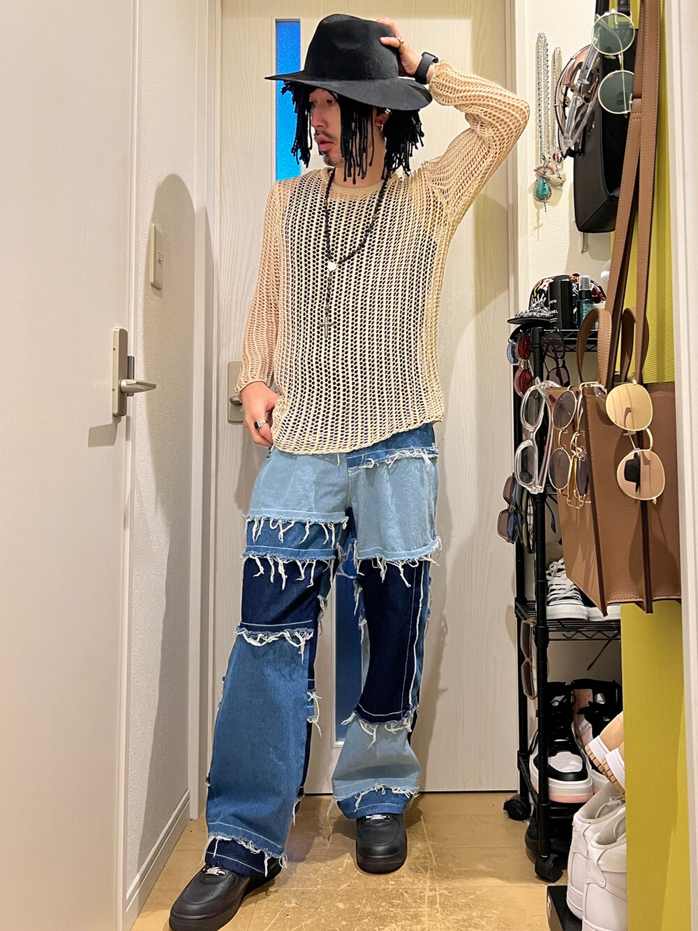 ブルー系のデニムパンツ、ブラック系のスニーカー、グレー系のハットを着用したメンズの秋コーディネートの3枚目の写真