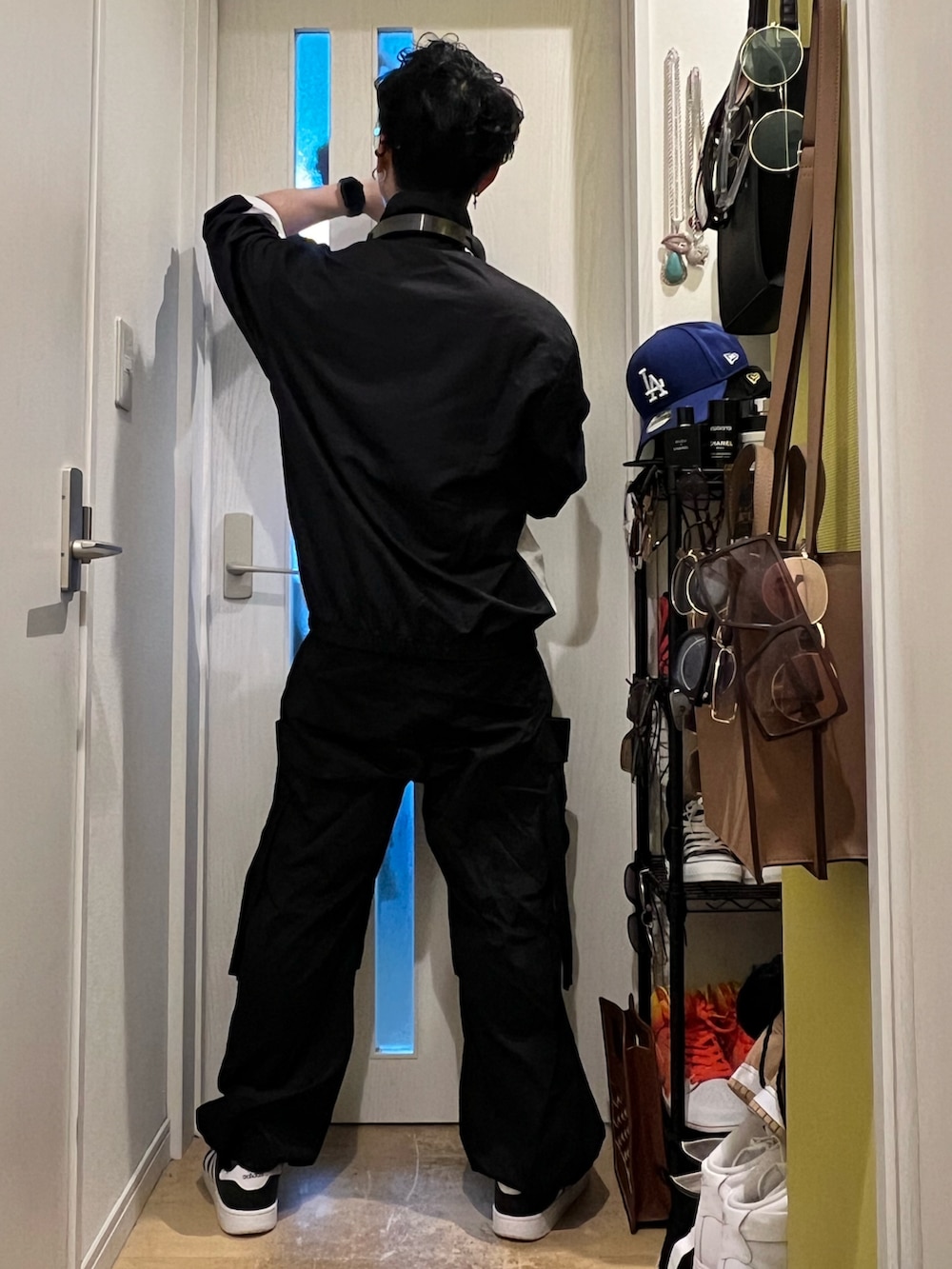 ブラック系のカーゴパンツ、ホワイト系のスニーカー、ブラック系のジャケット/アウターを着用したメンズの冬コーディネートの4枚目の写真