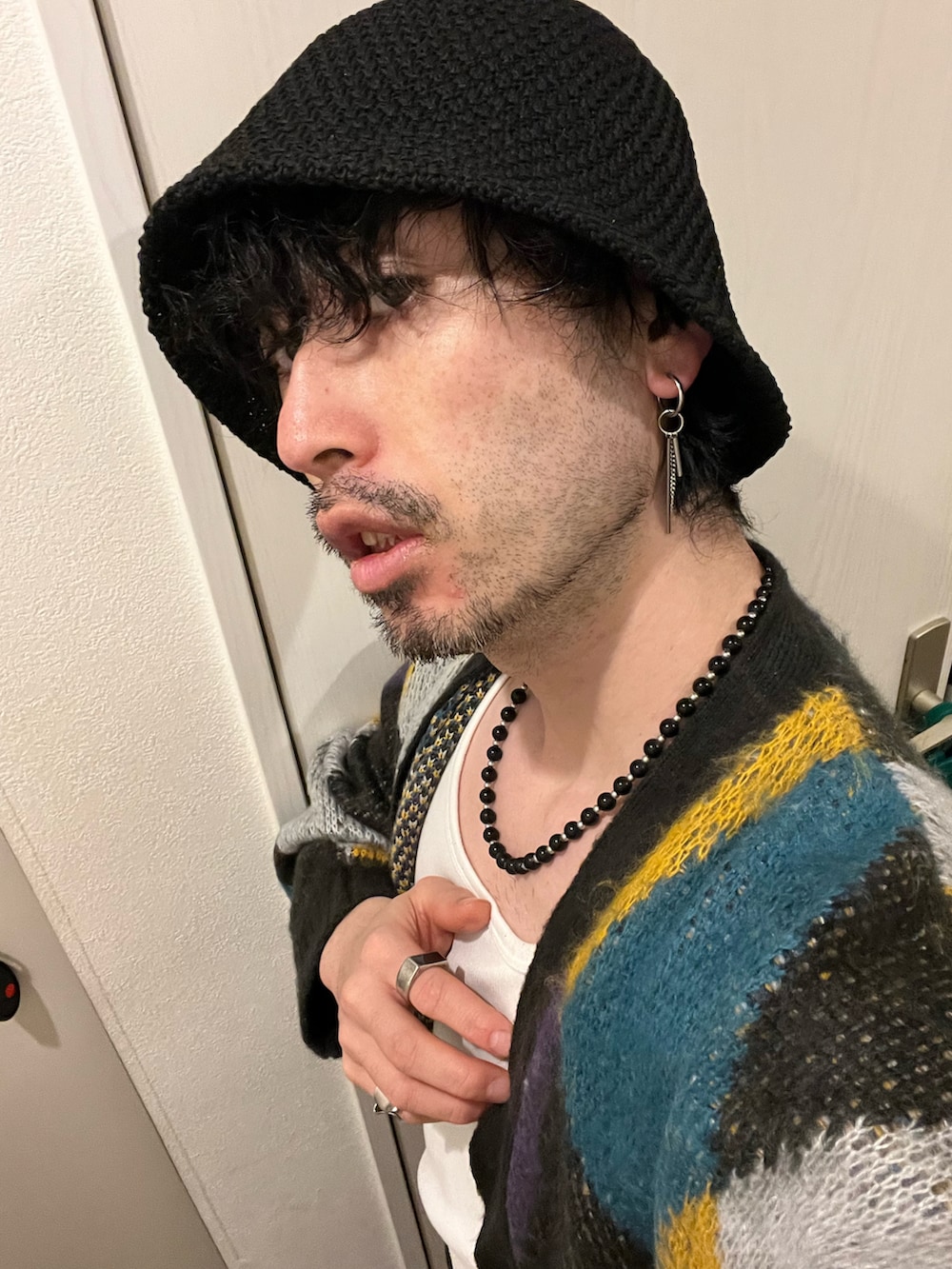 ブラック系のカーゴパンツ、ブラック系のブーツ、グリーン系のショルダーバッグを着用したメンズの春コーディネートの5枚目の写真