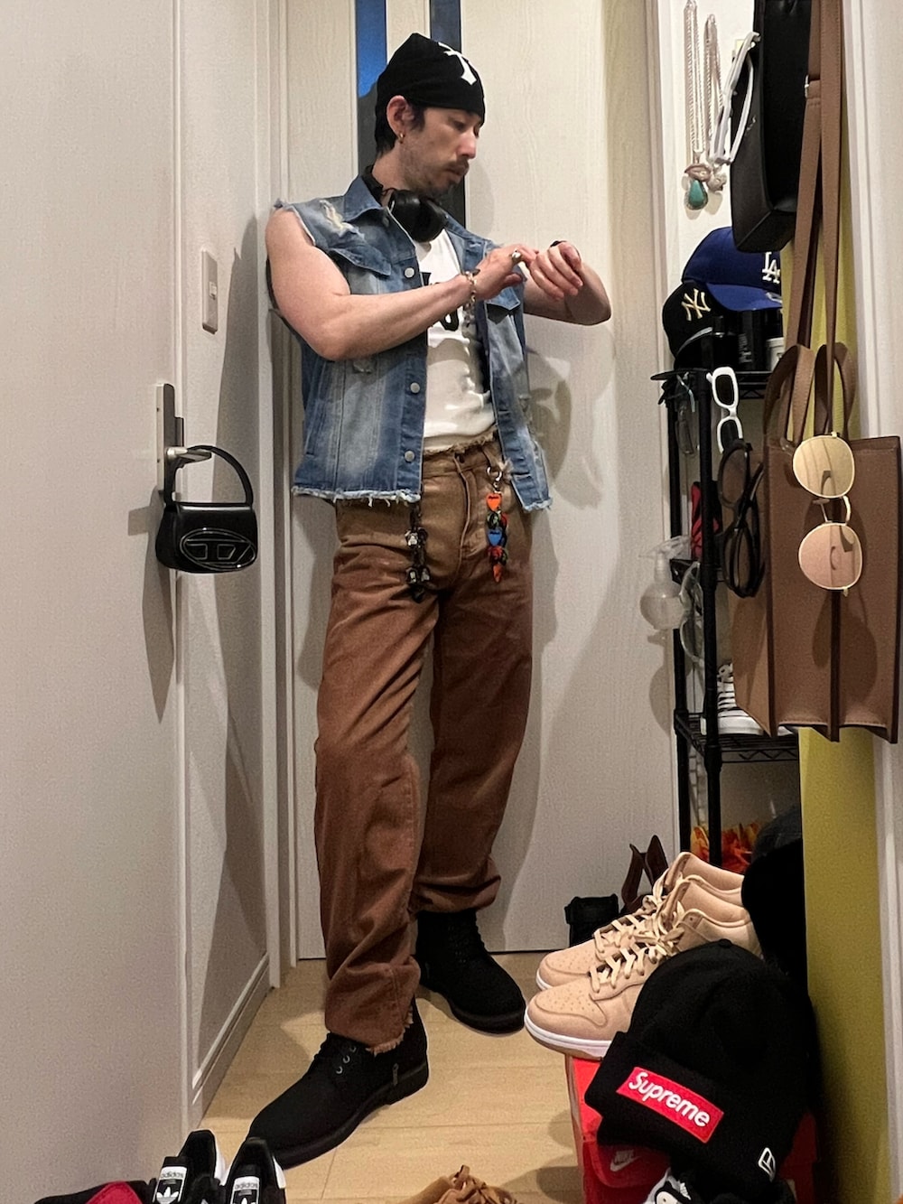 ブラック系のショルダーバッグ、ブラック系のブーツ、ホワイト系のタンクトップを着用したメンズの夏コーディネートの2枚目の写真