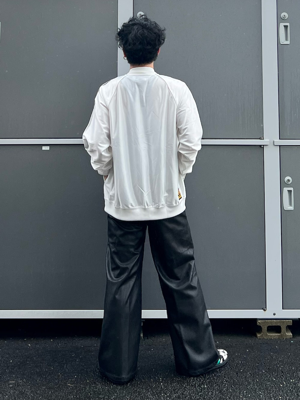 ホワイト系のジャージ、ブラック系のその他パンツ、ブラック系のスニーカーを着用したメンズの秋コーディネートの3枚目の写真