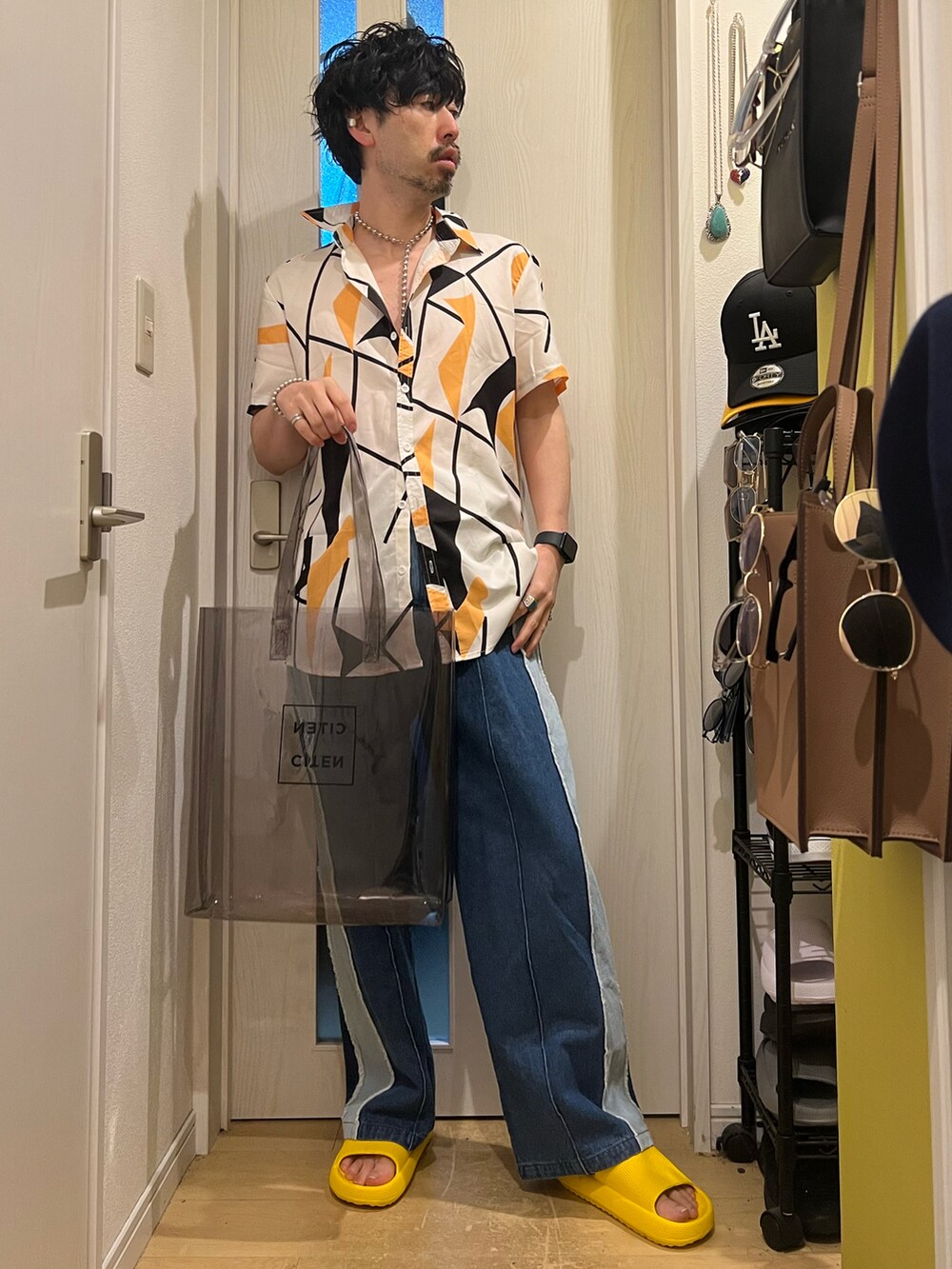 ブルー系のデニムパンツ、ブラック系のトートバッグ、その他のネックレスを着用したメンズの春コーディネートの3枚目の写真