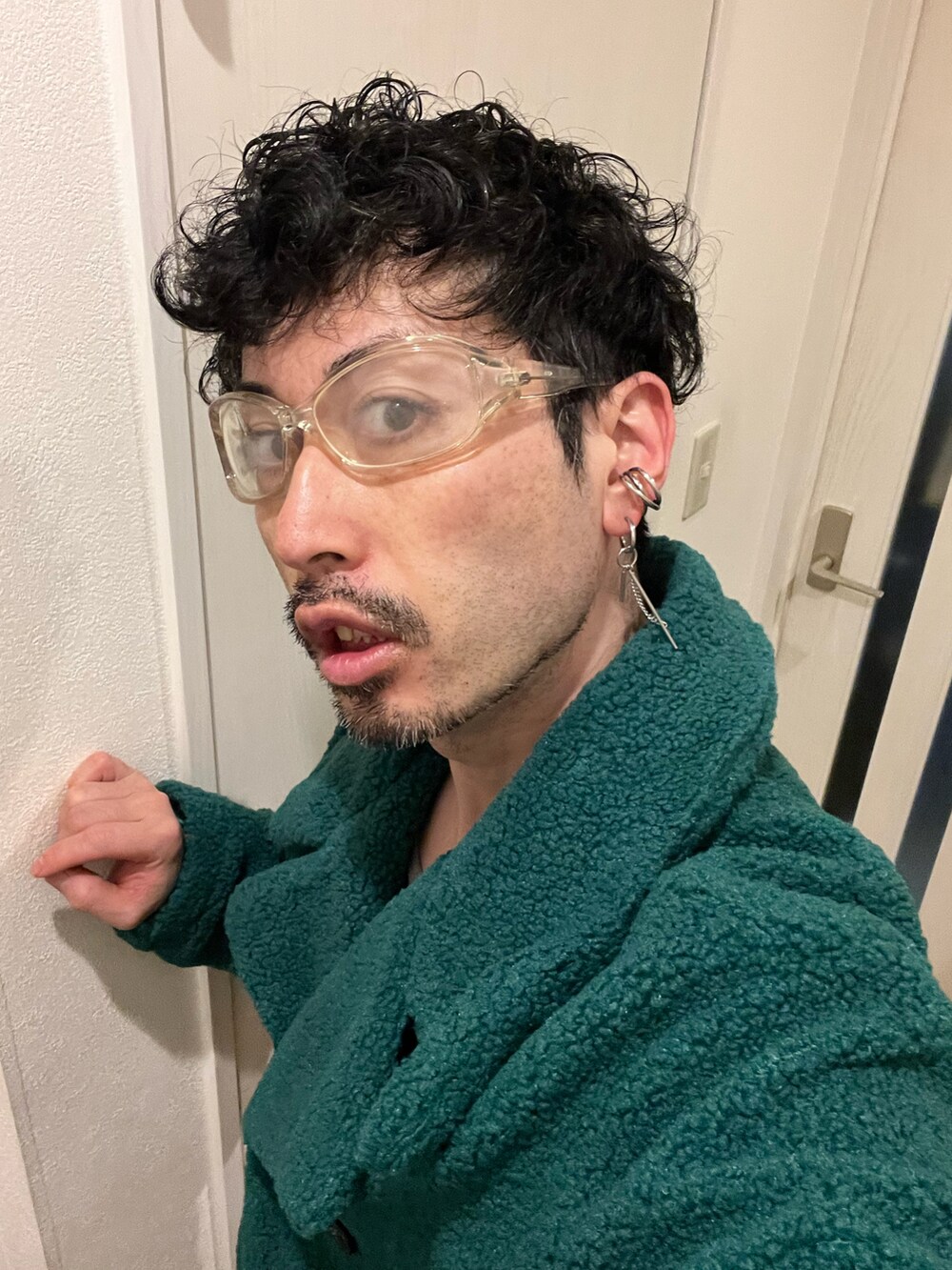 グリーン系のジャケット/アウター、ホワイト系のショルダーバッグ、ベージュ系のスラックスを着用したメンズの冬コーディネートの5枚目の写真