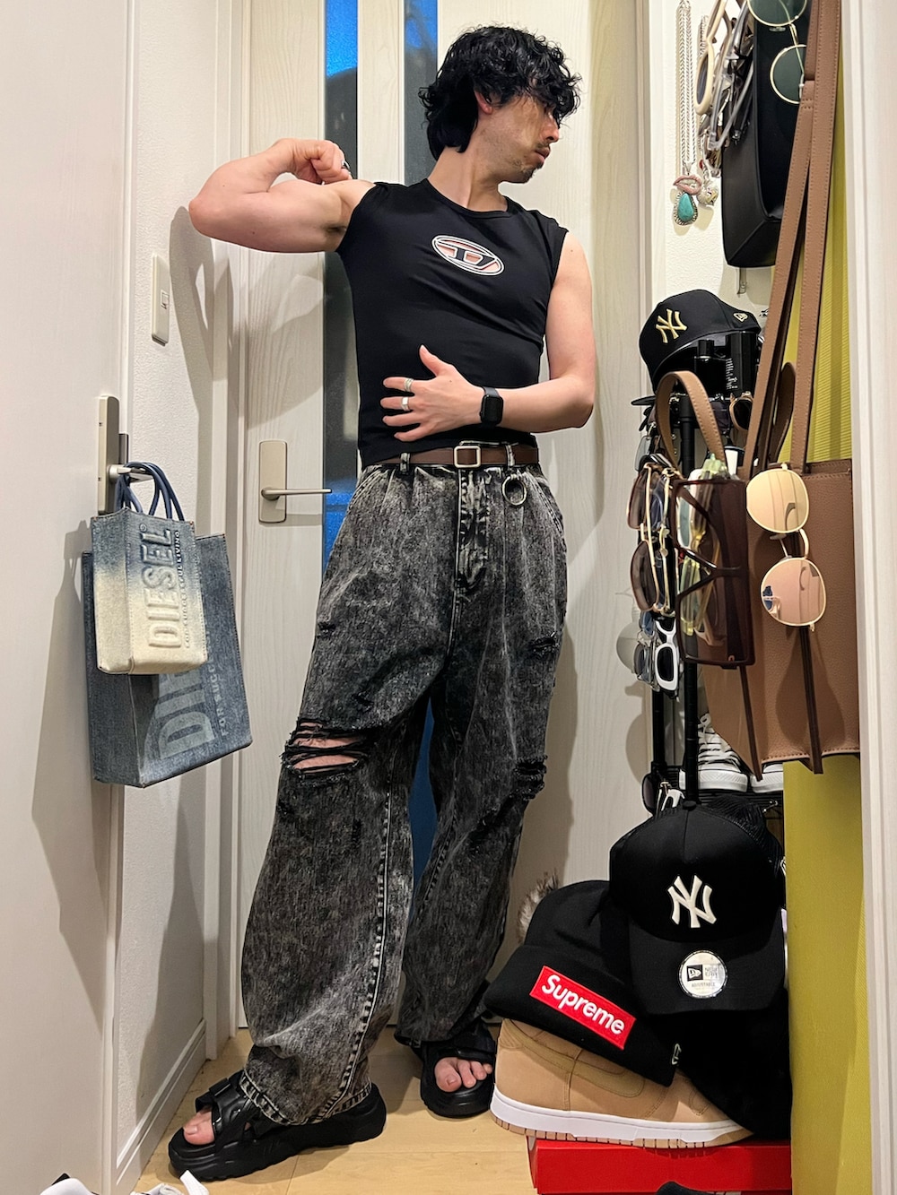 ブルー系のショルダーバッグ、ブラック系のデニムパンツ、ブラック系のサンダルを着用したメンズの春コーディネートの4枚目の写真