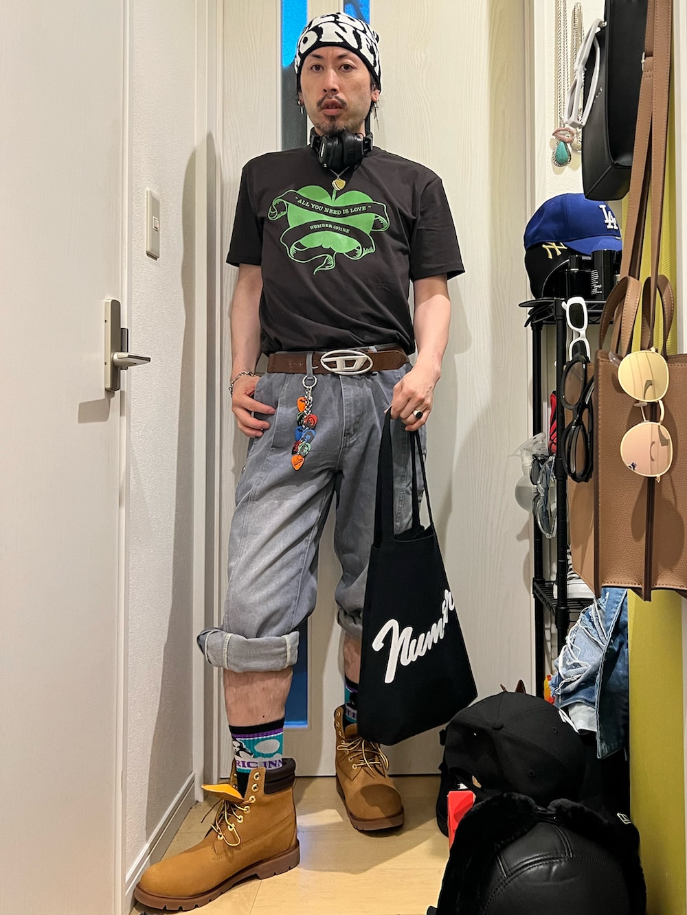 グレー系のTシャツ/カットソー、ブラック系のトートバッグ、ベージュ系のブーツを着用したメンズの夏コーディネートの2枚目の写真