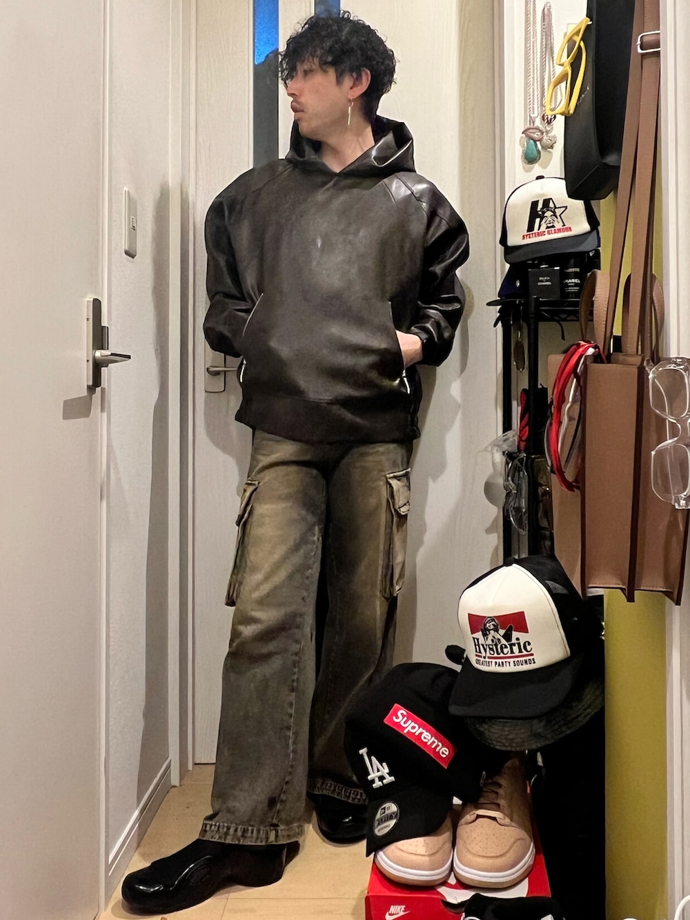 ブラウン系のパーカー、ブルー系のカーゴパンツ、ブラック系のサンダルを着用したメンズの秋コーディネートの2枚目の写真