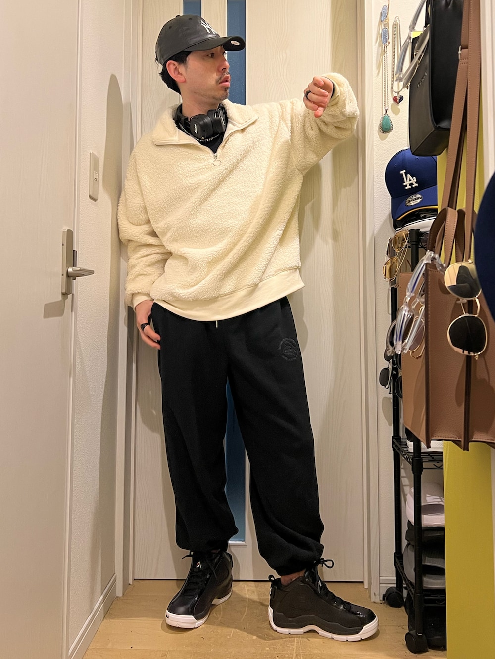 ブラック系のスニーカー、ホワイト系のスウェット、その他のキャップを着用したメンズの冬コーディネートの2枚目の写真
