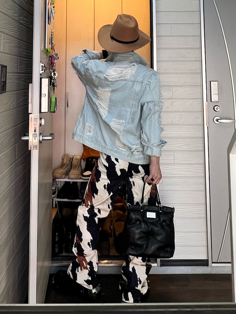 ホワイト系のタンクトップ、ブラック系のショルダーバッグ、その他のデニムパンツを着用したメンズの春コーディネートの3枚目の写真