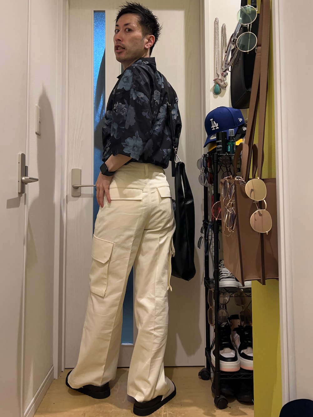 ブラック系のショルダーバッグ、ホワイト系のサンダル、ホワイト系のカーゴパンツを着用したメンズの夏コーディネートの4枚目の写真