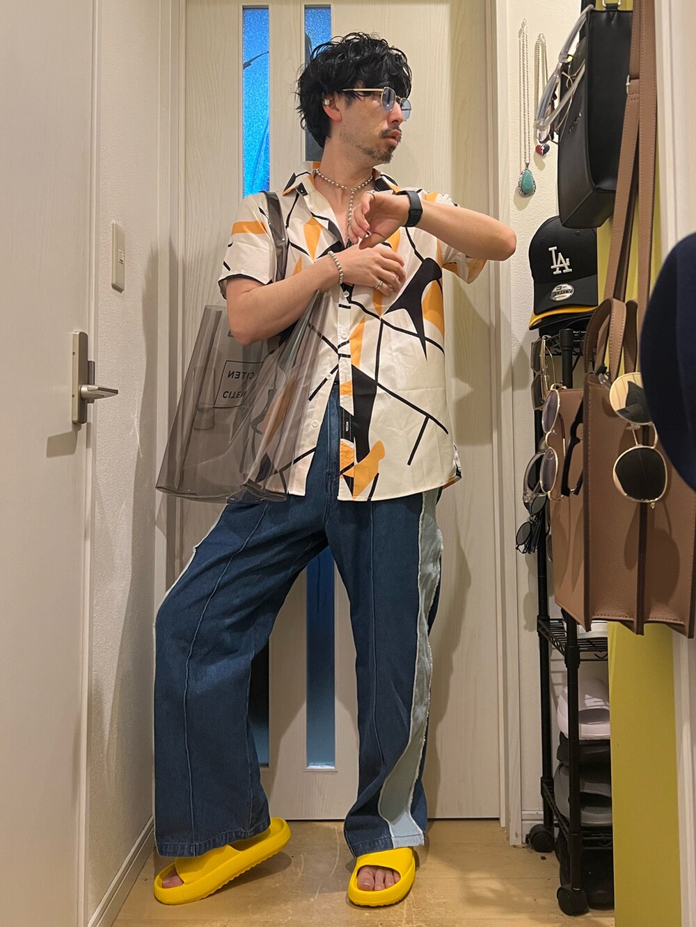 ブルー系のデニムパンツ、ブラック系のトートバッグ、その他のネックレスを着用したメンズの春コーディネートの2枚目の写真