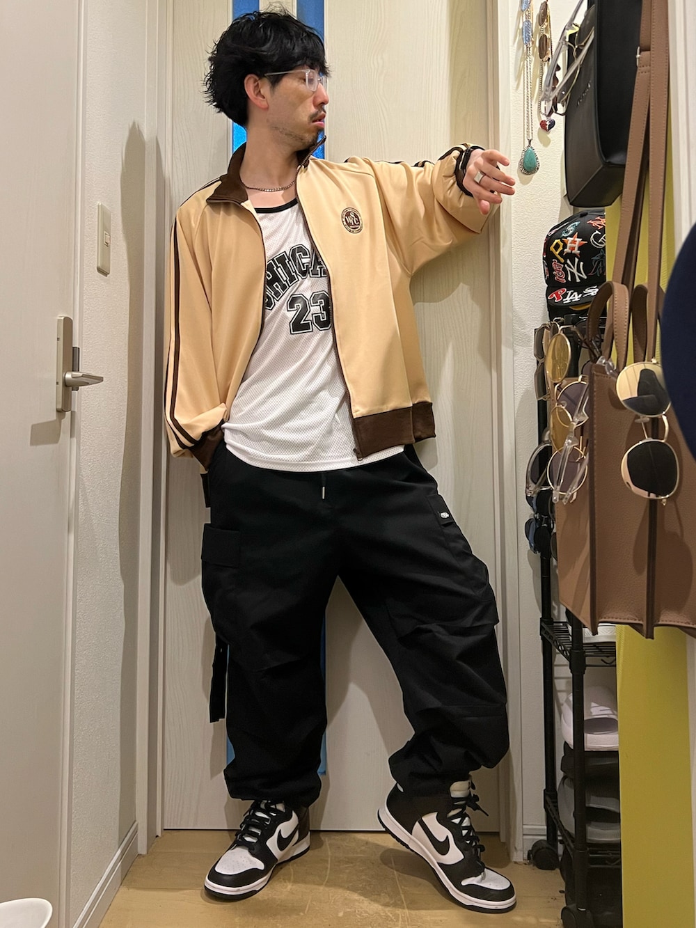 ベージュ系のその他アウター、ブラック系のカーゴパンツ、ホワイト系のスニーカーを着用したメンズの春コーディネートの3枚目の写真