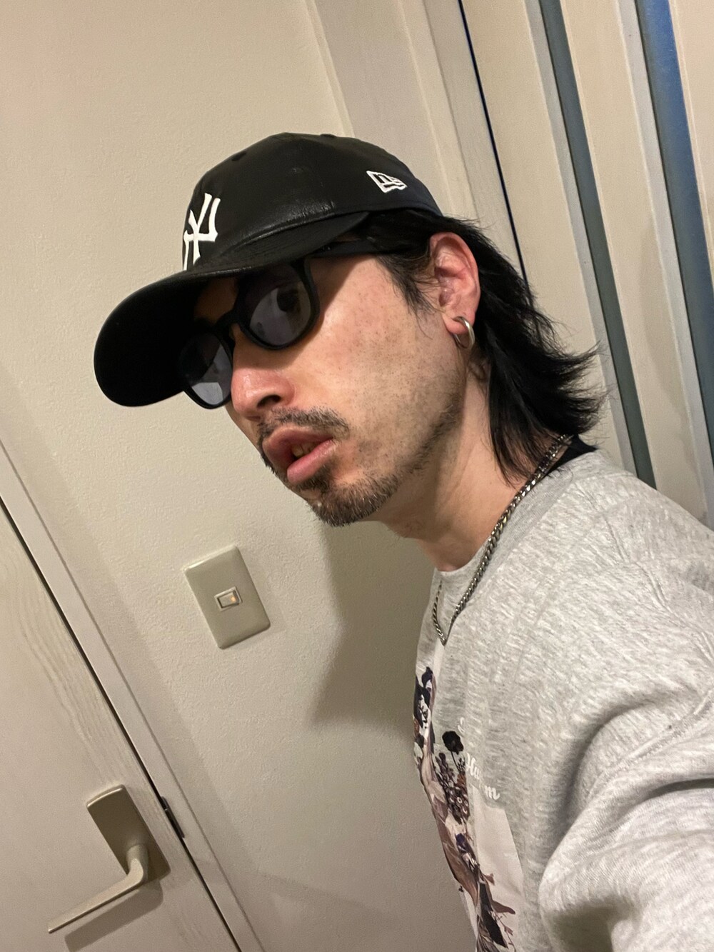 ブラウン系のデニムパンツ、ホワイト系のスニーカー、グレー系のスウェットを着用したメンズの冬コーディネートの3枚目の写真