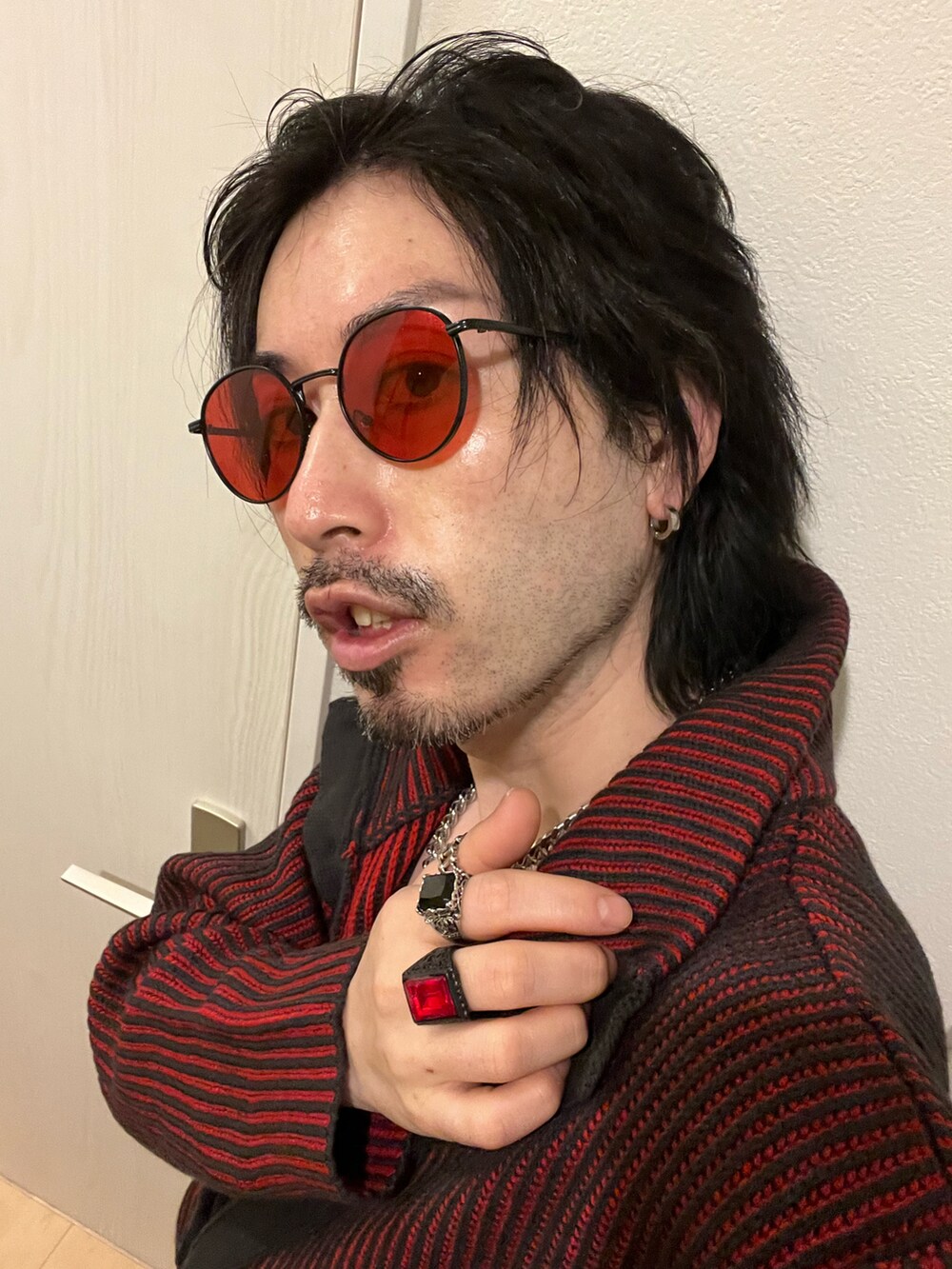 ブラック系のブーツ、グレー系のスラックス、レッド系のカーディガン/ボレロを着用したメンズの冬コーディネートの4枚目の写真