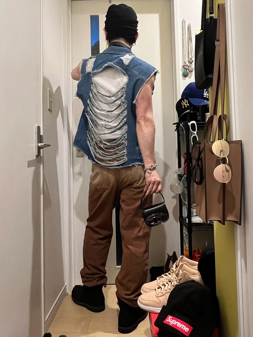 ブラック系のショルダーバッグ、ブラック系のブーツ、ホワイト系のタンクトップを着用したメンズの夏コーディネートの3枚目の写真