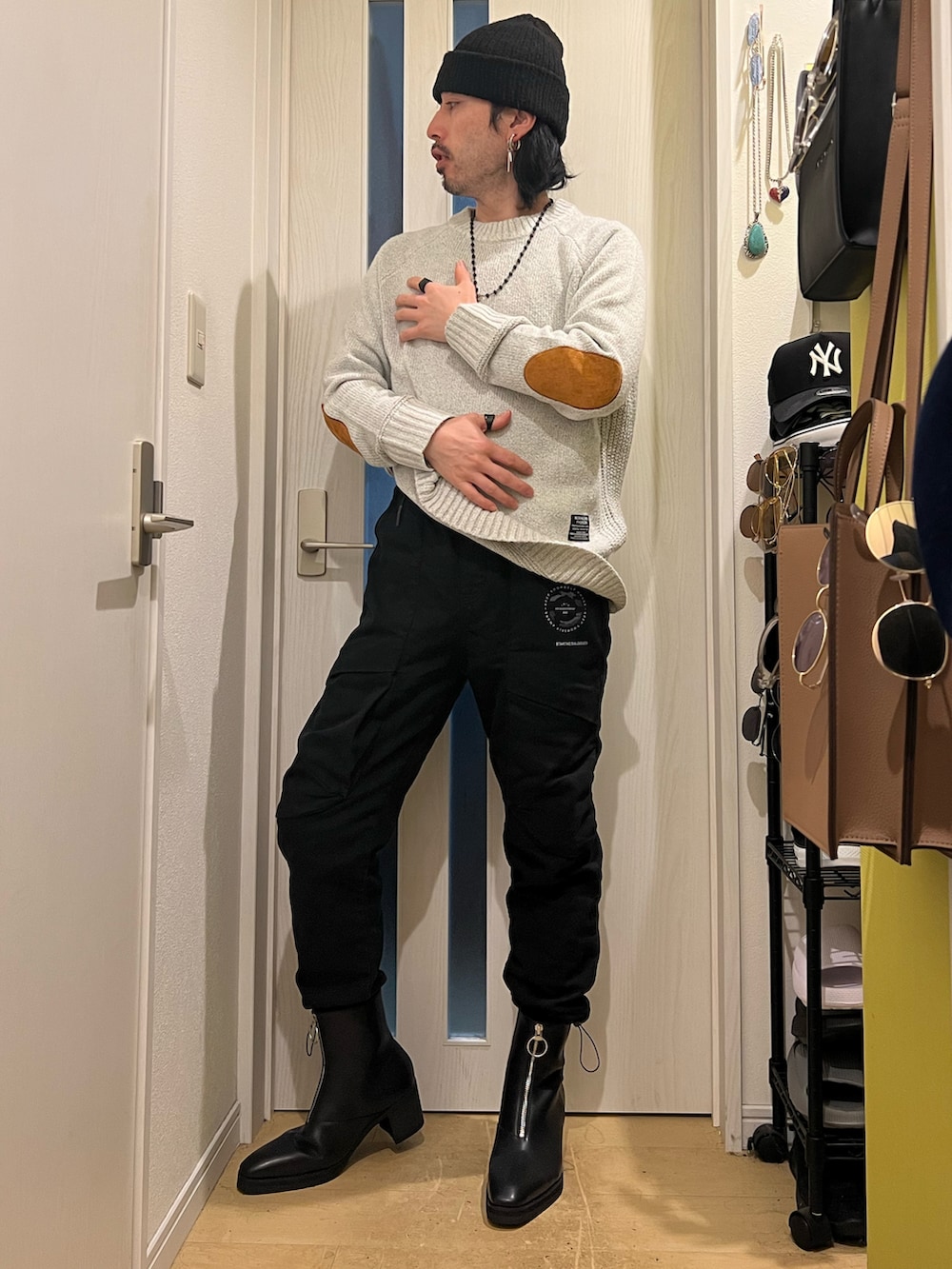 ホワイト系のニット/セーター、ブラック系のブーツを着用したメンズの冬コーディネートの2枚目の写真