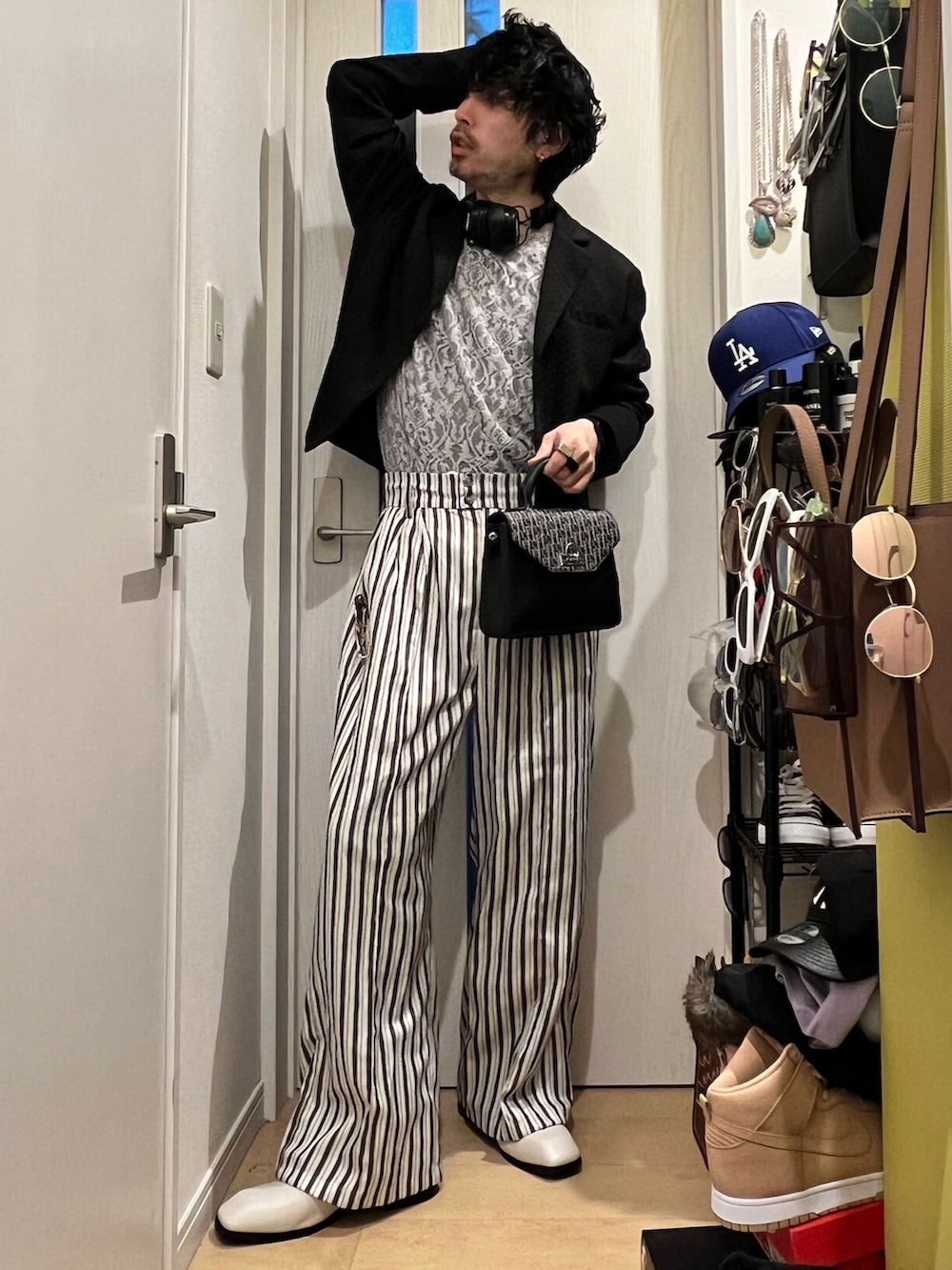 ホワイト系のその他パンツ、ブラック系のショルダーバッグ、ブラック系のジャケット/アウターを着用したメンズの春コーディネートの3枚目の写真