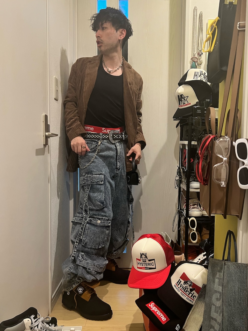 ブラウン系のテーラードジャケット、ブラック系のタンクトップ、ブラック系のショルダーバッグを着用したメンズの冬コーディネートの2枚目の写真