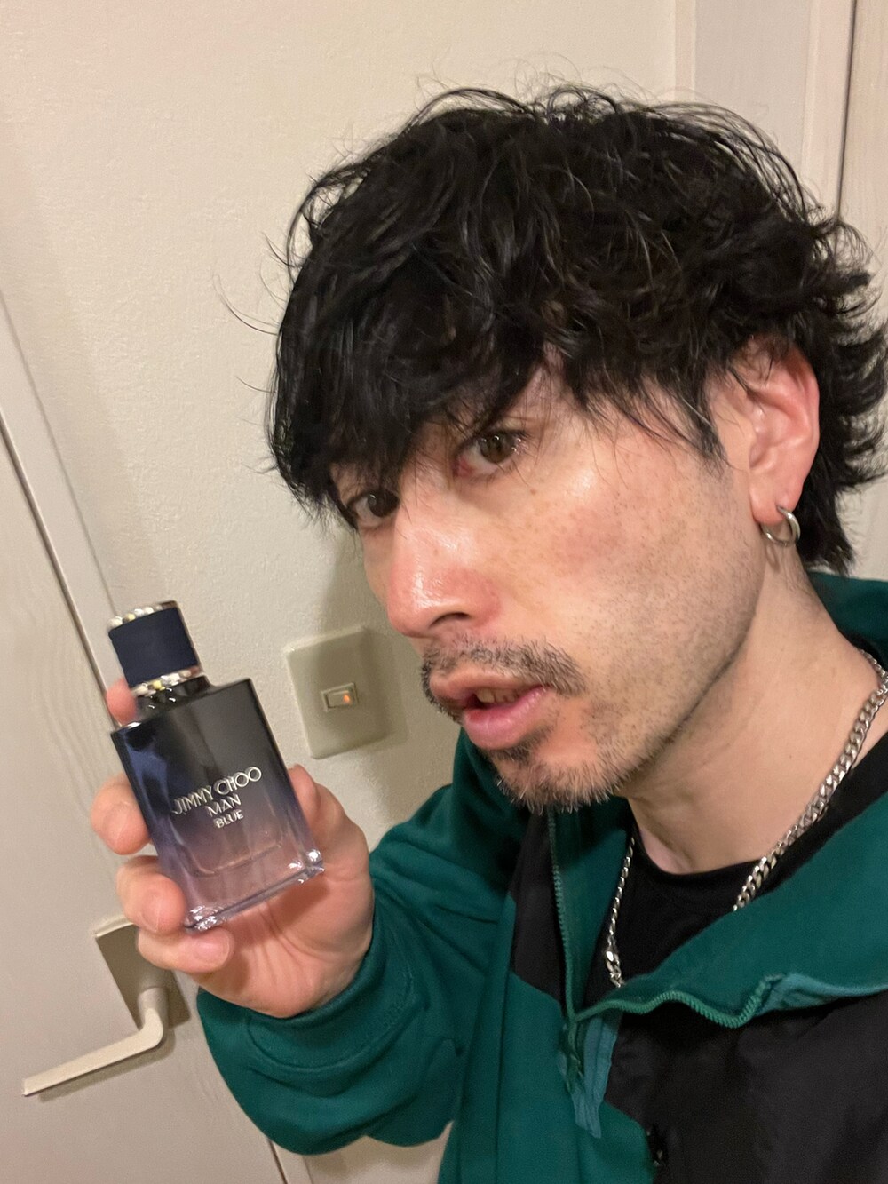 グリーン系のスウェット、ブラック系のカーゴパンツ、ホワイト系のトートバッグを着用したメンズの春コーディネートの5枚目の写真