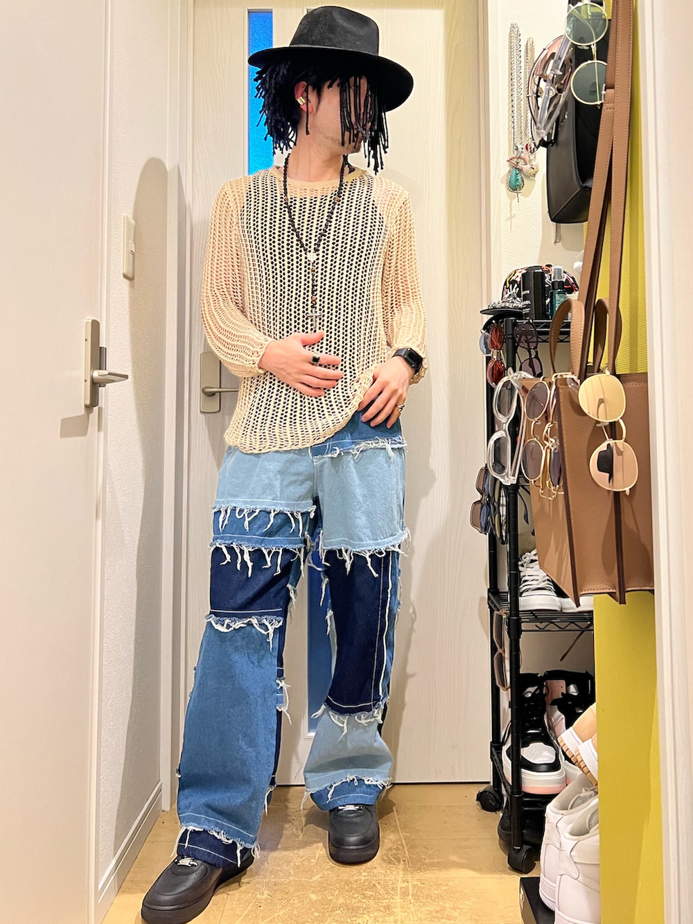 ブルー系のデニムパンツ、ブラック系のスニーカー、グレー系のハットを着用したメンズの秋コーディネートの2枚目の写真