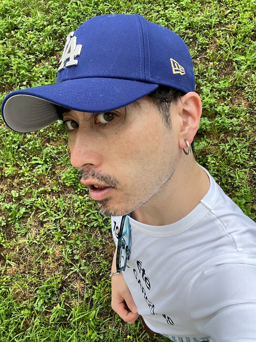 ホワイト系のTシャツ/カットソー、ブルー系のデニムパンツ、ブラック系のスニーカーを着用したメンズの夏コーディネートの5枚目の写真