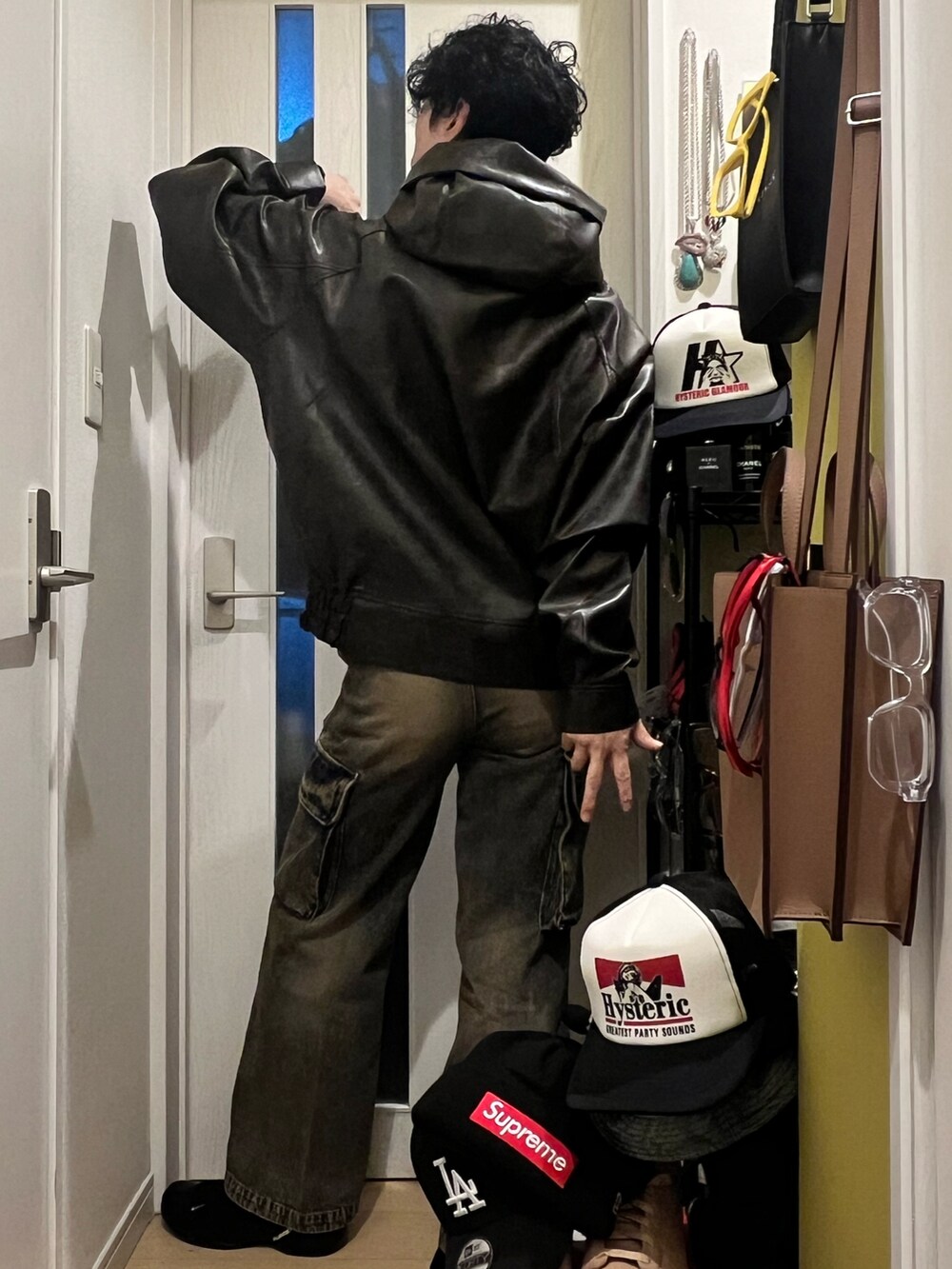 ブラウン系のパーカー、ブルー系のカーゴパンツ、ブラック系のサンダルを着用したメンズの秋コーディネートの3枚目の写真