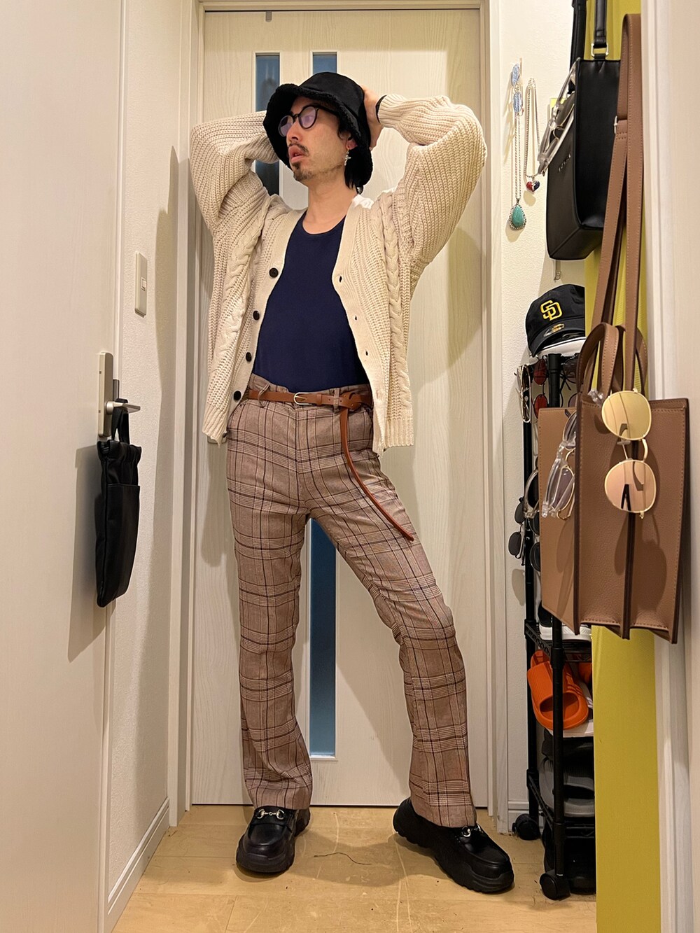 ホワイト系のカーディガン/ボレロ、グリーン系のショルダーバッグ、ブラウン系のスラックスを着用したメンズの秋コーディネートの3枚目の写真