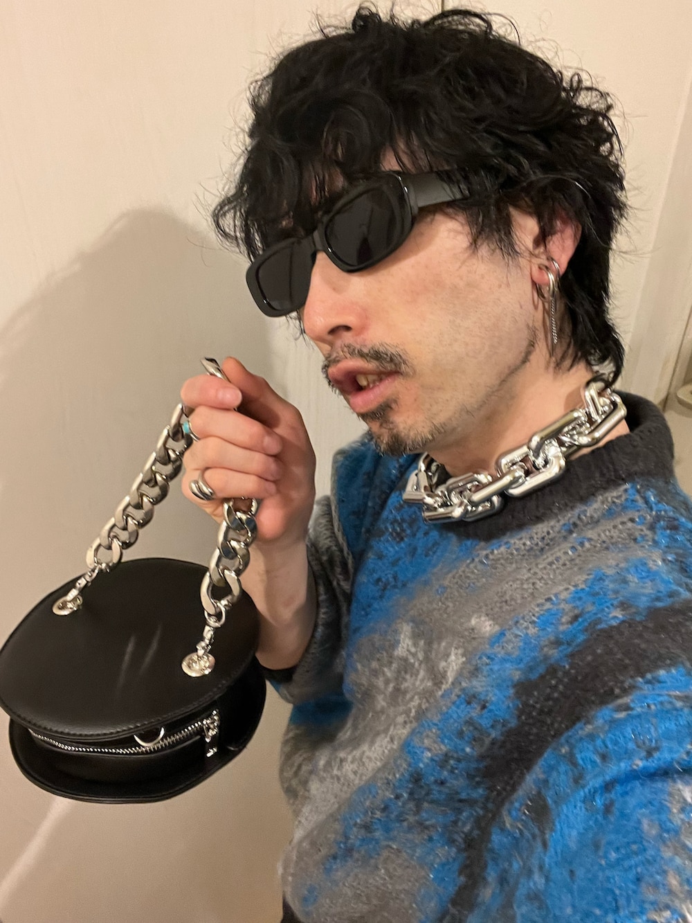 グリーン系のデニムパンツ、ブルー系のブーツ、ブラック系のショルダーバッグを着用したメンズの春コーディネートの4枚目の写真