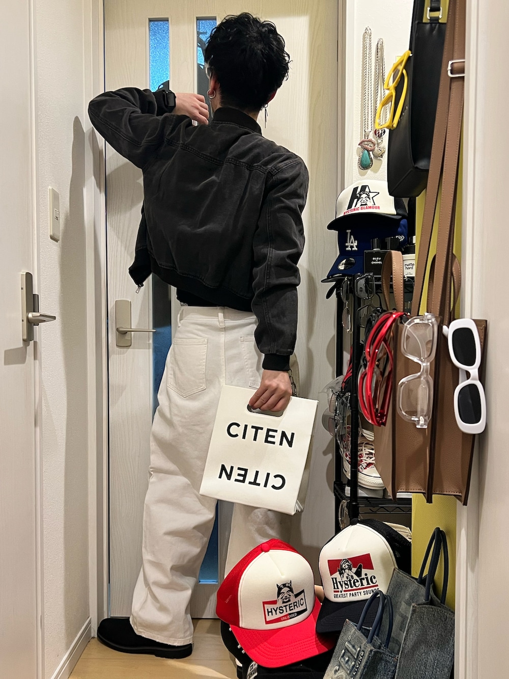 ホワイト系のデニムパンツ、ブラック系のブーツ、ホワイト系のハンドバッグを着用したメンズの冬コーディネートの3枚目の写真