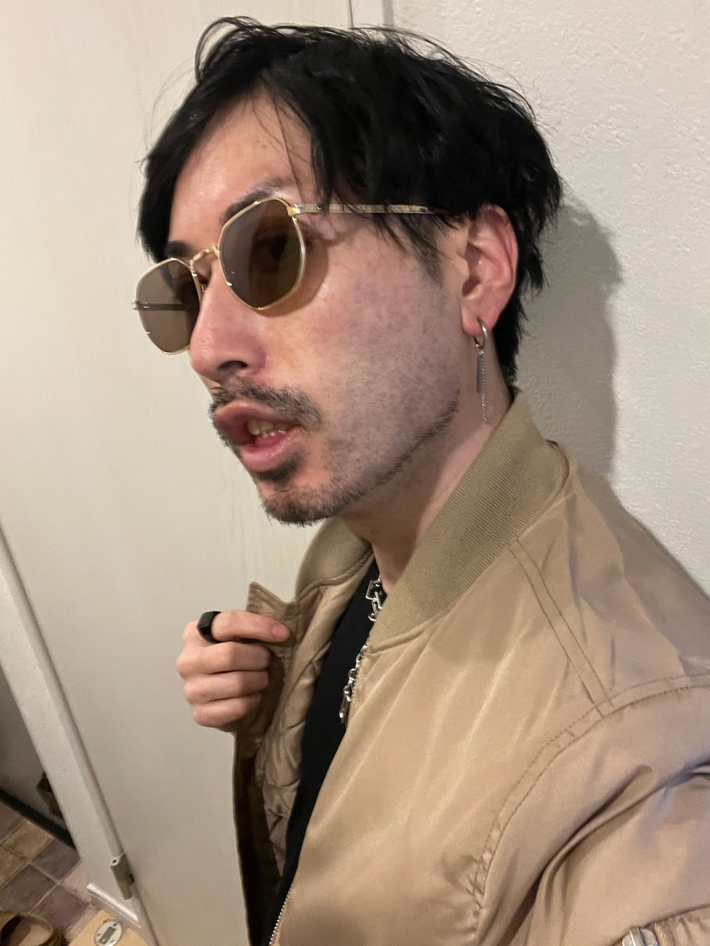 ベージュ系のMA-1、ブラック系のデニムパンツ、ブラック系のスニーカーを着用したメンズの春コーディネートの4枚目の写真