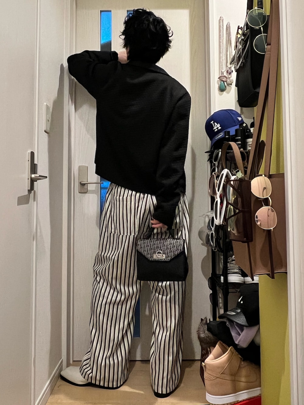 ホワイト系のその他パンツ、ブラック系のショルダーバッグ、ブラック系のジャケット/アウターを着用したメンズの春コーディネートの4枚目の写真