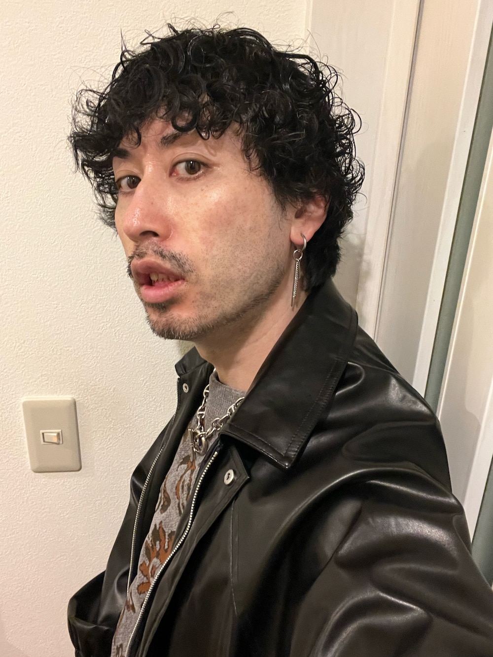 グレー系のニット/セーター、イエロー系のハンドバッグ、ブラック系のブルゾンを着用したメンズの春コーディネートの4枚目の写真