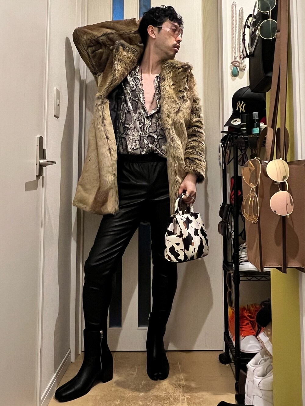 ブラック系のスウェットパンツ、ブラック系のブーツ、ホワイト系のショルダーバッグを着用したメンズの冬コーディネートの2枚目の写真