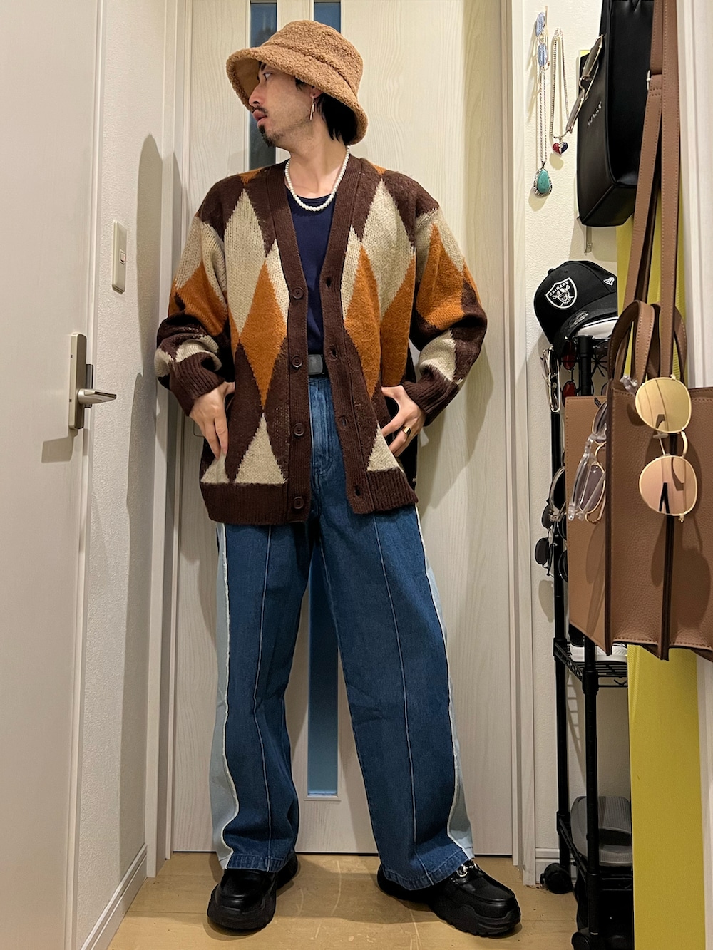 ブラウン系のカーディガン/ボレロ、ブルー系のデニムパンツ、ブラック系のスニーカーを着用したメンズの秋コーディネートの2枚目の写真