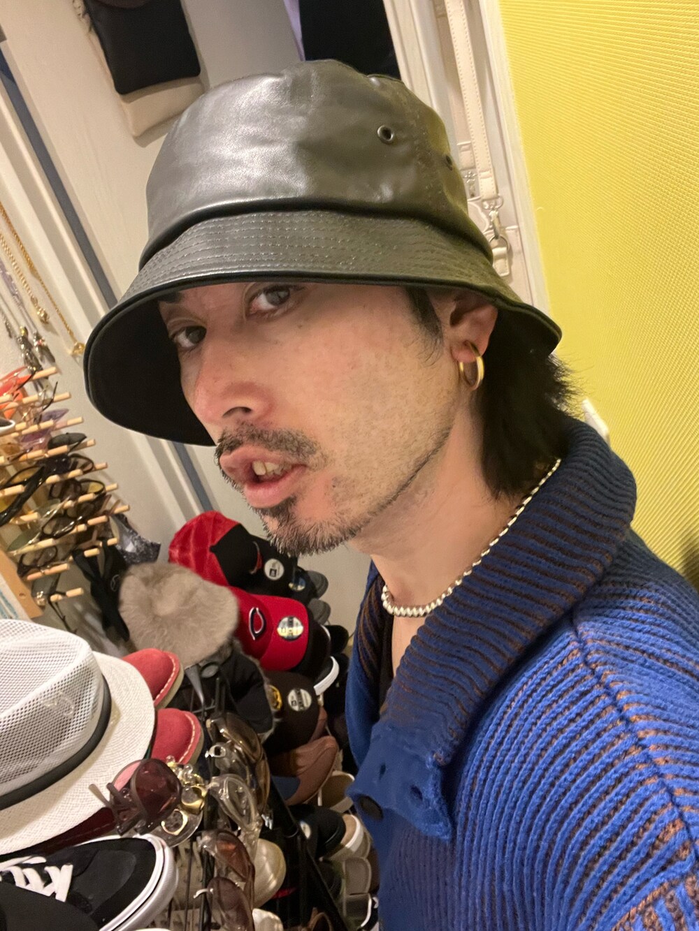 ブラック系のスラックス、ブルー系のカーディガン/ボレロ、ベージュ系のタンクトップを着用したメンズの冬コーディネートの4枚目の写真