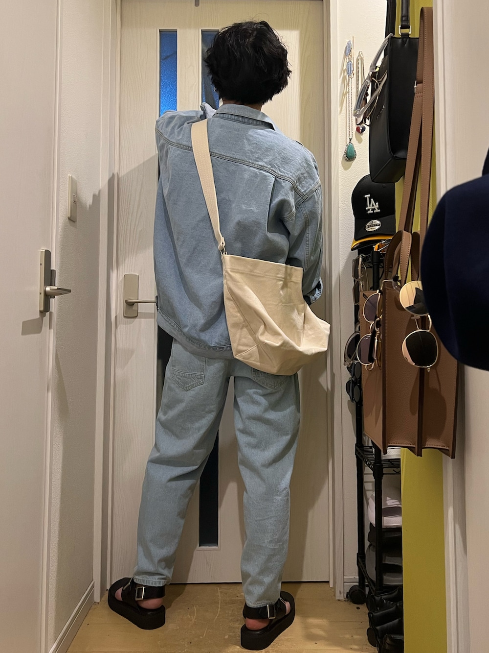 ブルー系のデニムジャケット、ブルー系のデニムパンツ、ブラック系のサンダルを着用したメンズの春コーディネートの4枚目の写真