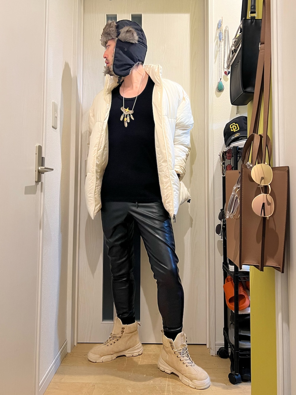 ホワイト系のダウンジャケット/コート、ブラック系のその他パンツ、ブラック系のキャップを着用したメンズの冬コーディネートの2枚目の写真