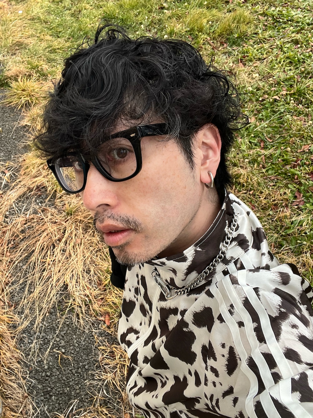 ブラック系のデニムパンツ、ブラック系のスニーカー、ホワイト系のジャージを着用したメンズの秋コーディネートの5枚目の写真