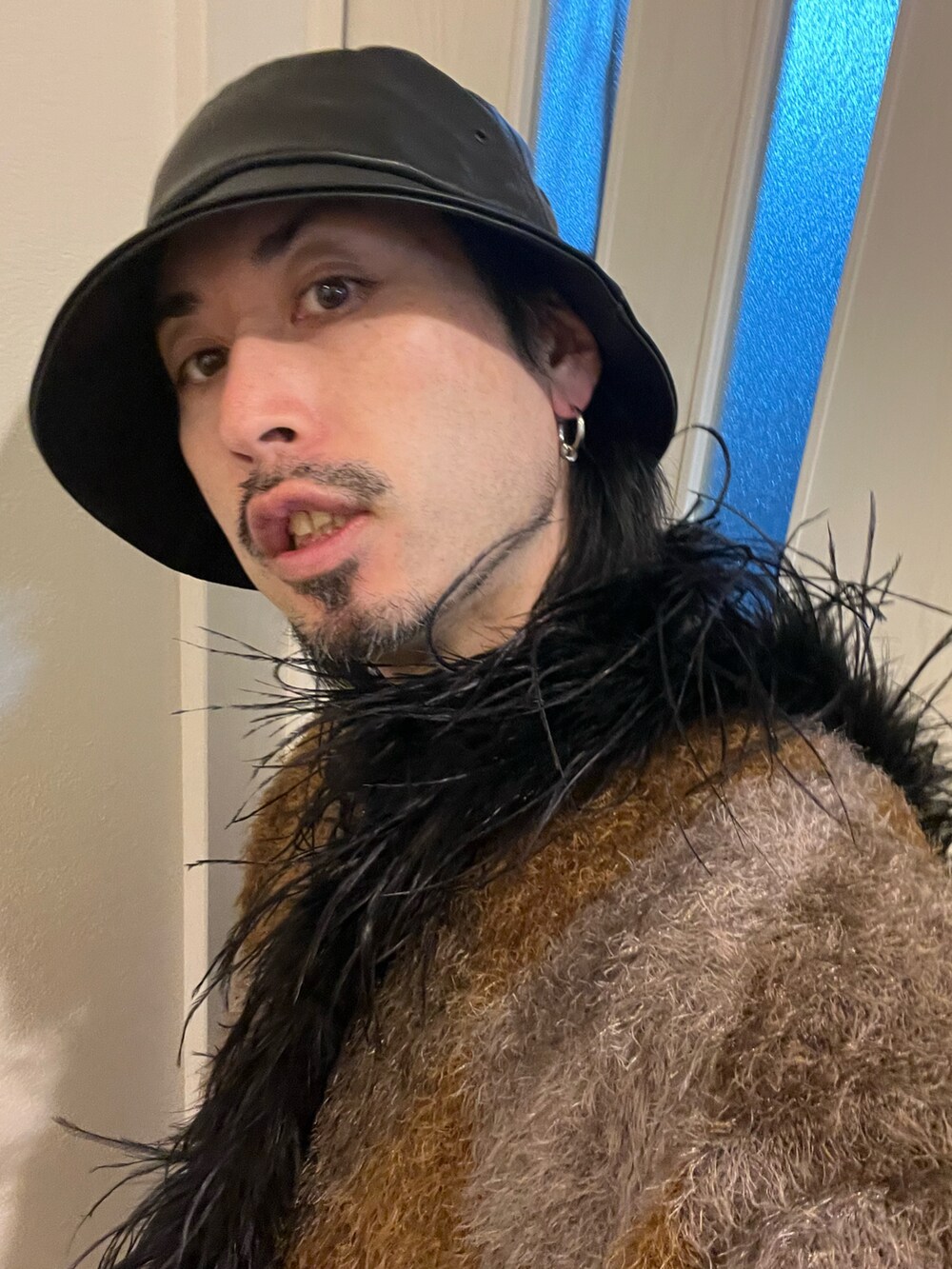 ブラウン系のニット/セーター、ベージュ系のスラックス、ブラック系のブーツを着用したメンズの冬コーディネートの4枚目の写真