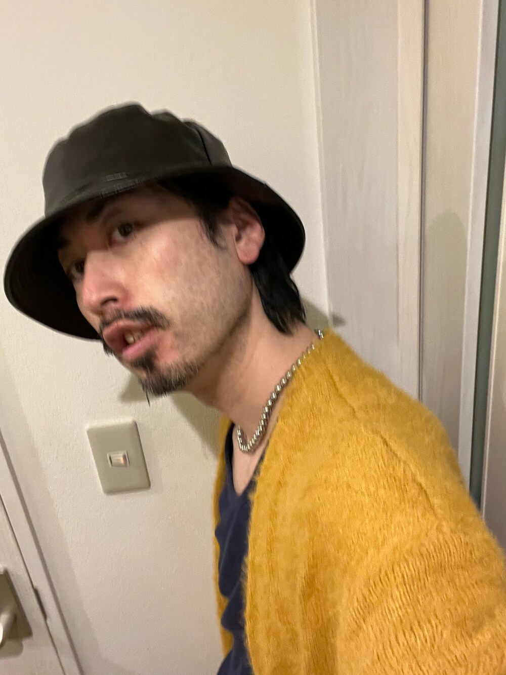 イエロー系のカーディガン/ボレロ、ブラック系のその他パンツ、ブラック系のスニーカーを着用したメンズの秋コーディネートの4枚目の写真