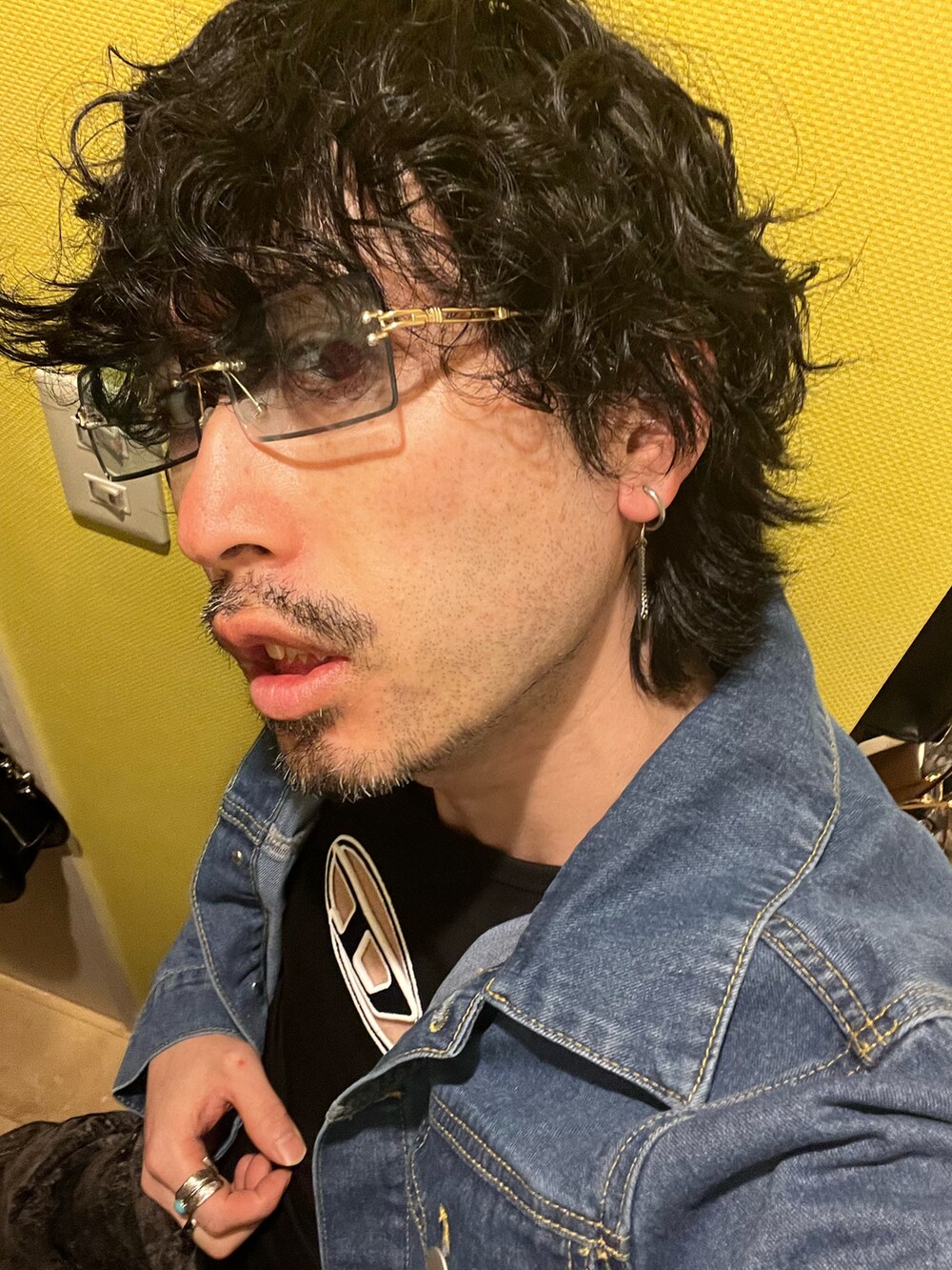 ブルー系のショルダーバッグ、ブラック系のデニムパンツ、ブラック系のサンダルを着用したメンズの春コーディネートの5枚目の写真