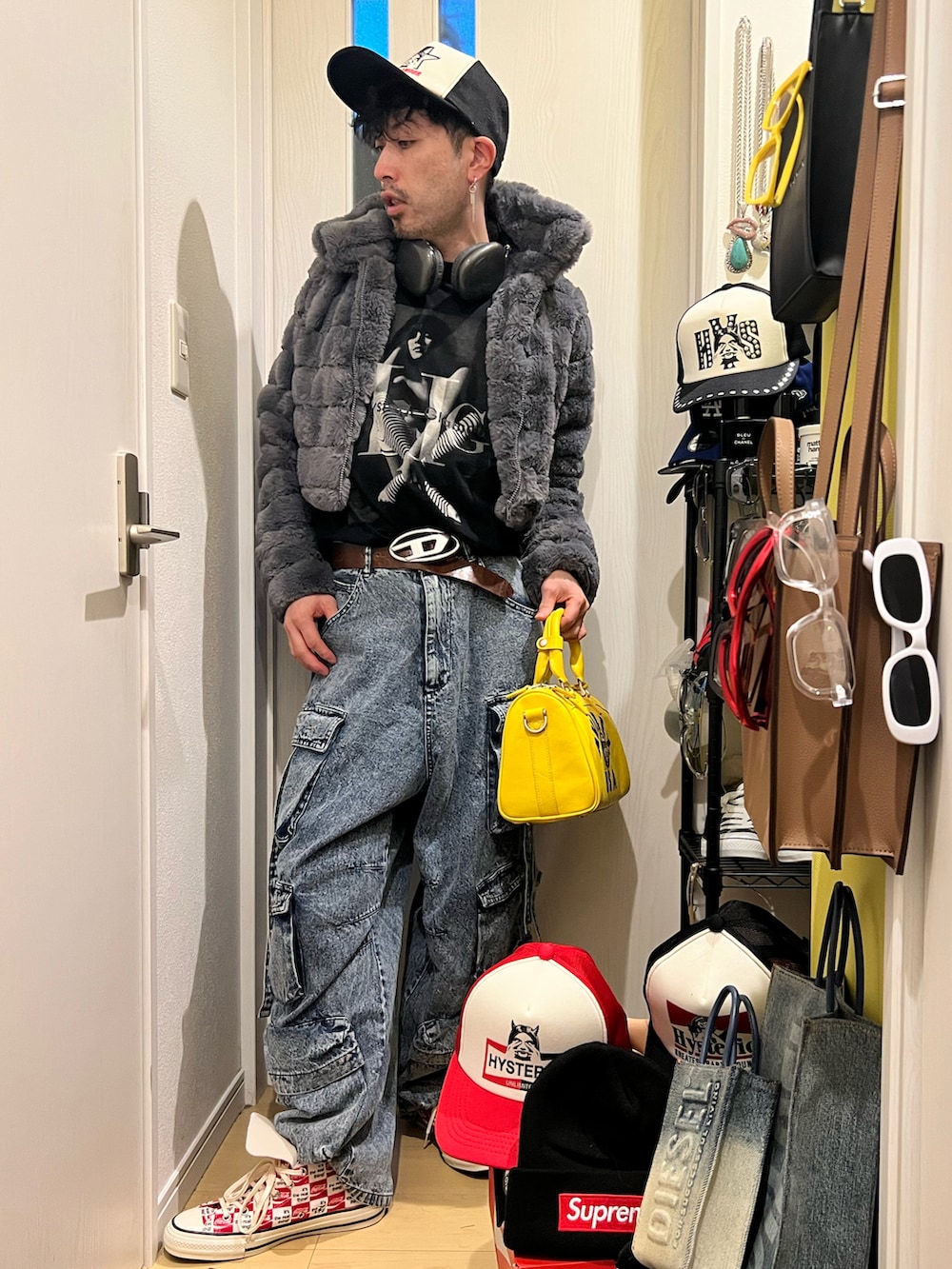 イエロー系のボストンバッグ、ブルー系のカーゴパンツ、レッド系のスニーカーを着用したメンズの冬コーディネートの2枚目の写真