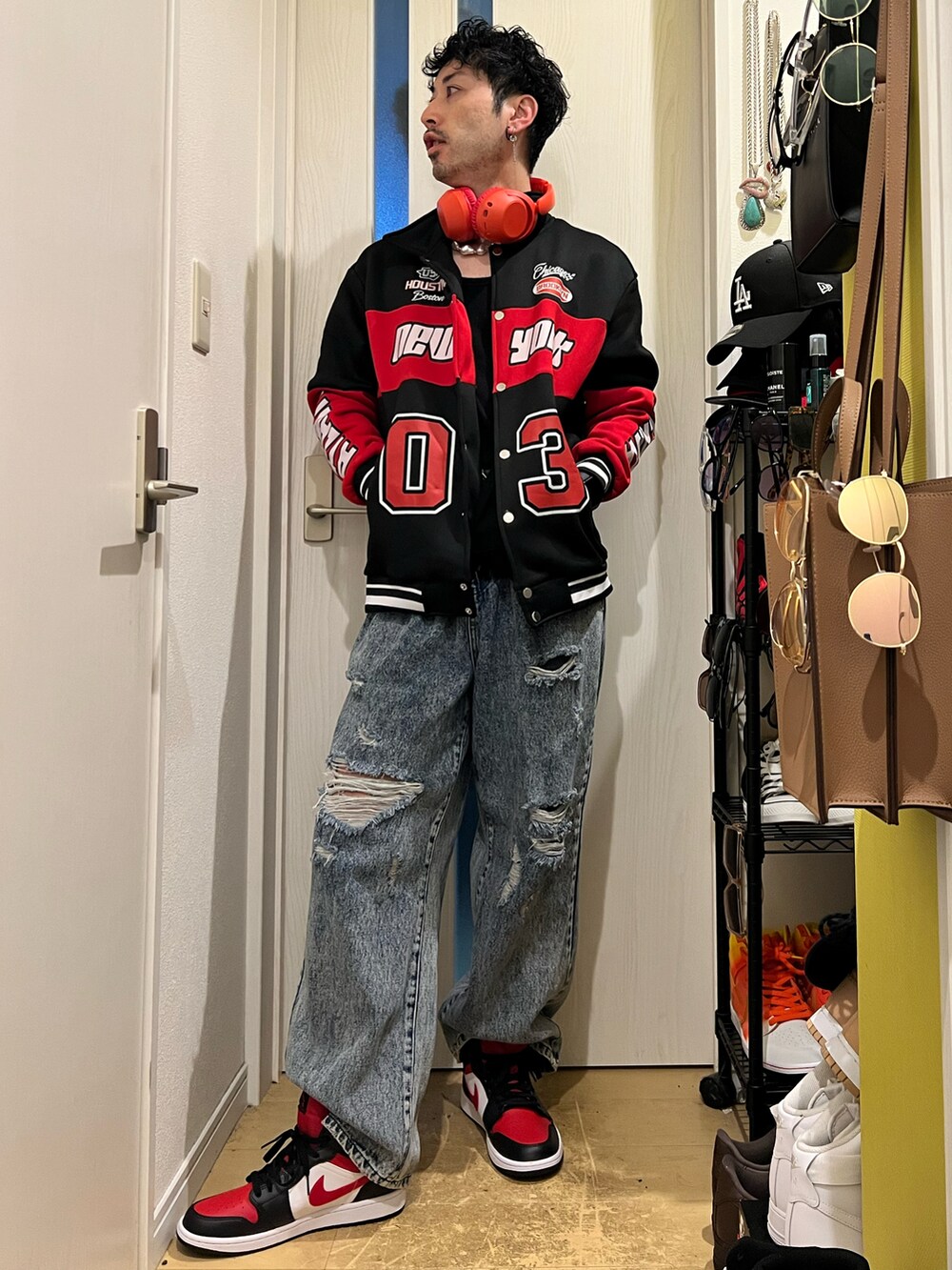 ブルー系のデニムパンツ、ブラック系のスニーカー、レッド系のジャケット/アウターを着用したメンズの冬コーディネートの3枚目の写真