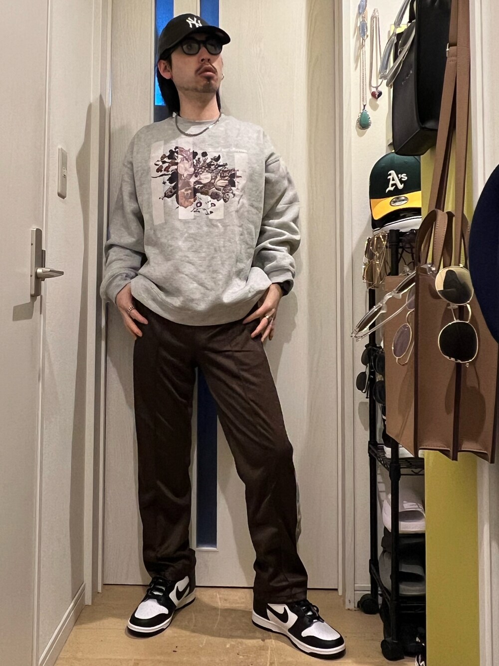 ブラウン系のデニムパンツ、ホワイト系のスニーカー、グレー系のスウェットを着用したメンズの冬コーディネートの2枚目の写真