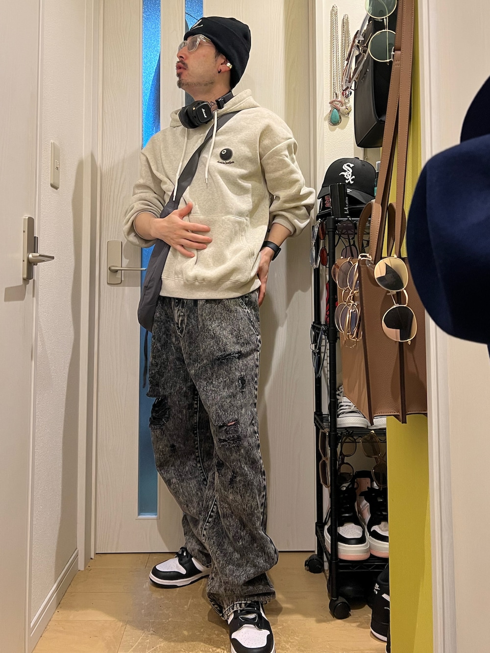 ブラック系のデニムパンツ、ホワイト系のスニーカー、グレー系のショルダーバッグを着用したメンズの夏コーディネートの3枚目の写真