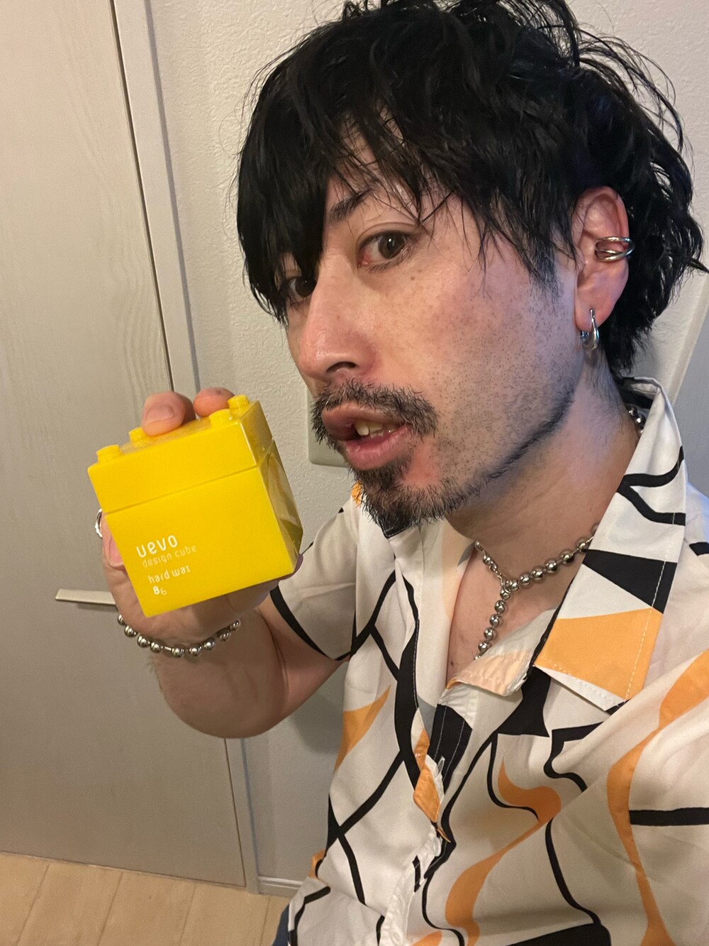 ブルー系のデニムパンツ、ブラック系のトートバッグ、その他のネックレスを着用したメンズの春コーディネートの5枚目の写真