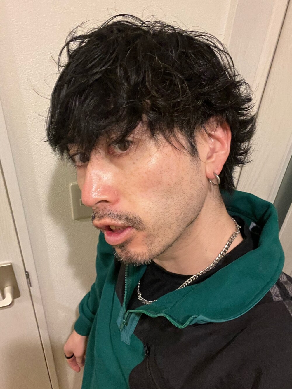 グリーン系のスウェット、ブラック系のカーゴパンツ、ホワイト系のトートバッグを着用したメンズの春コーディネートの4枚目の写真