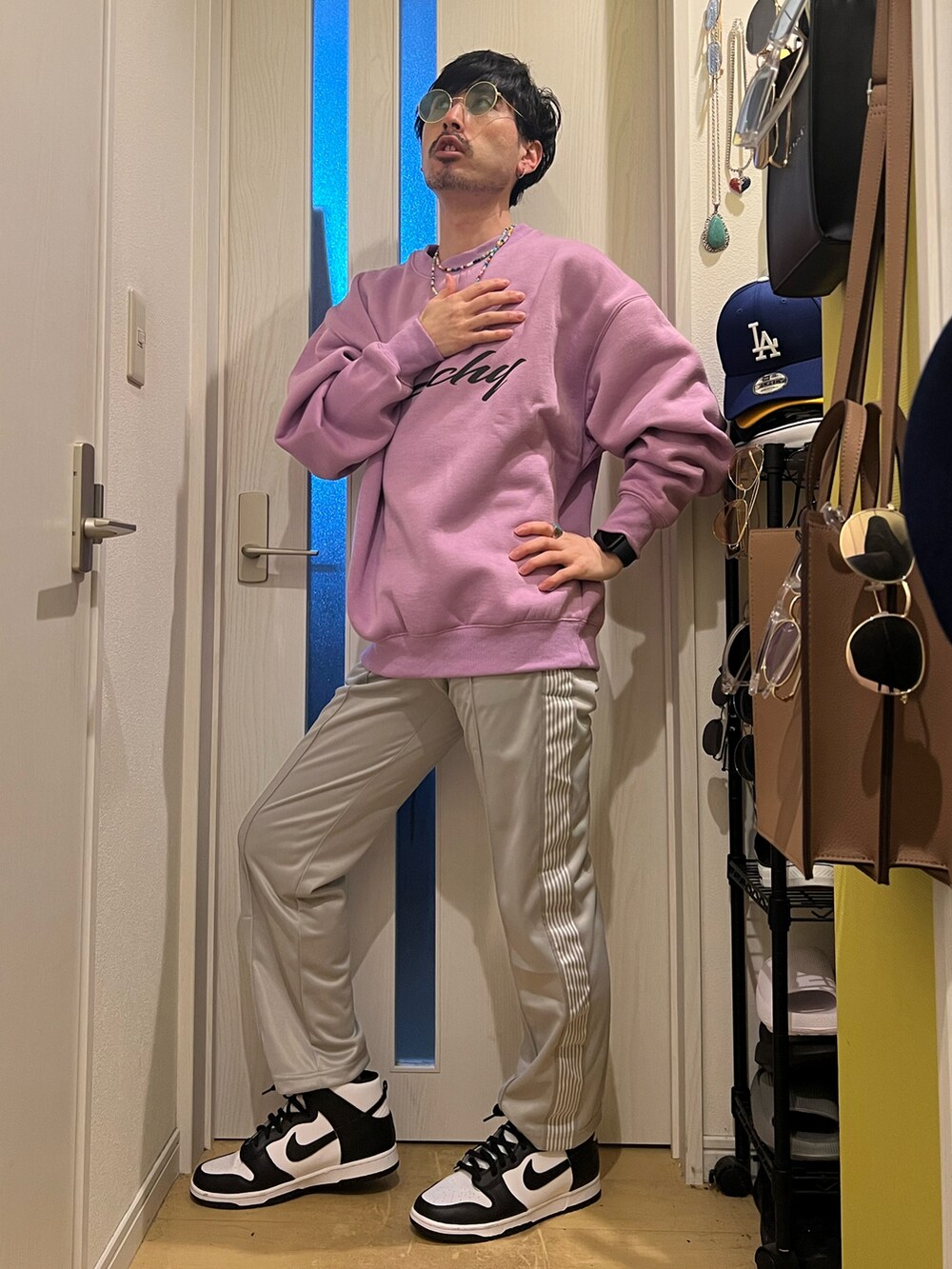 パープル系のスウェット、グレー系のデニムパンツ、ホワイト系のスニーカーを着用したメンズの春コーディネートの3枚目の写真