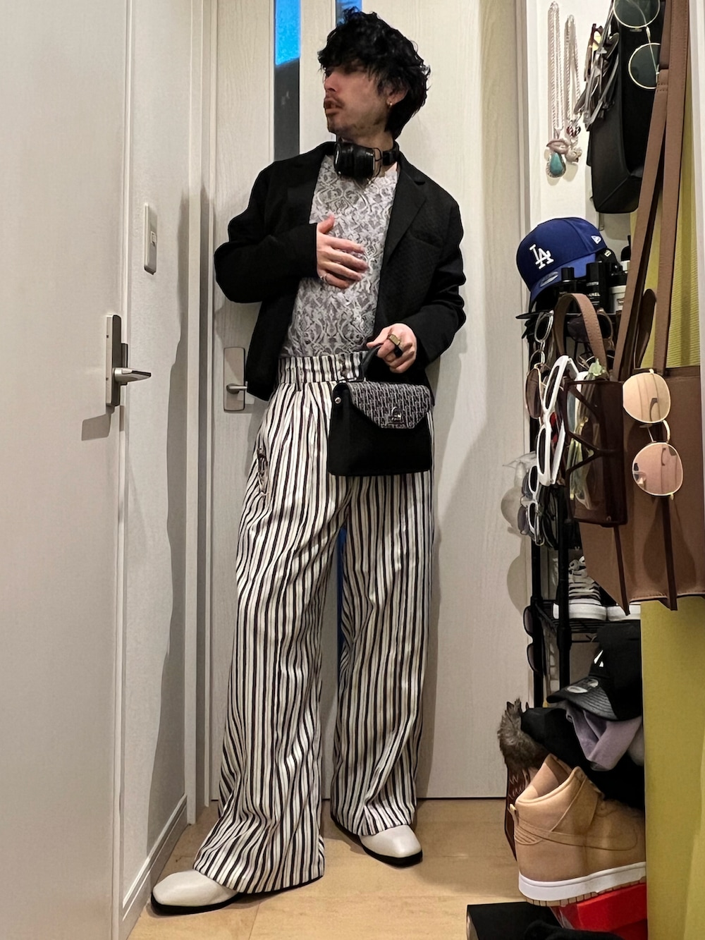 ホワイト系のその他パンツ、ブラック系のショルダーバッグ、ブラック系のジャケット/アウターを着用したメンズの春コーディネートの2枚目の写真