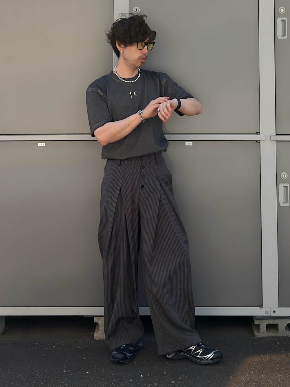 ブラック系のトートバッグ、グレー系のTシャツ/カットソー、ブラック系のスニーカーを着用したメンズの夏コーディネートの3枚目の写真