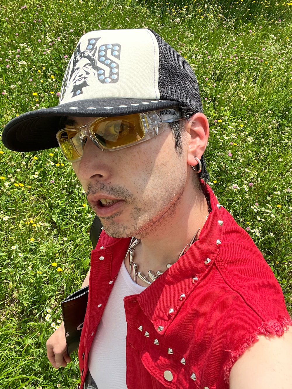 ブラック系のトートバッグ、ベージュ系のブーツ、ブルー系のパンツを着用したメンズの夏コーディネートの5枚目の写真